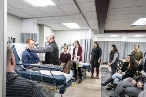 Students look onward as instructor demonstrates ENT exam